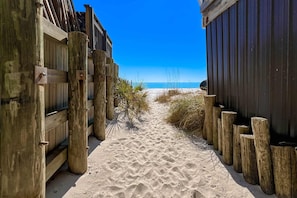 A sandy pathway flanked by wooden fences leading to a beach. - Miramar Beach Villas - Caminata Corta B (Miramar Beach)