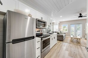 Eine moderne Küche mit Edelstahlgeräten, weißen Schränken und Holzboden.