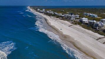 A coastal property with beachfront villas, a sandy beach, and ocean views.