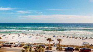 Ein Strand mit weißem Sand, Palmen und wolkenlosem, blauem Himmel.