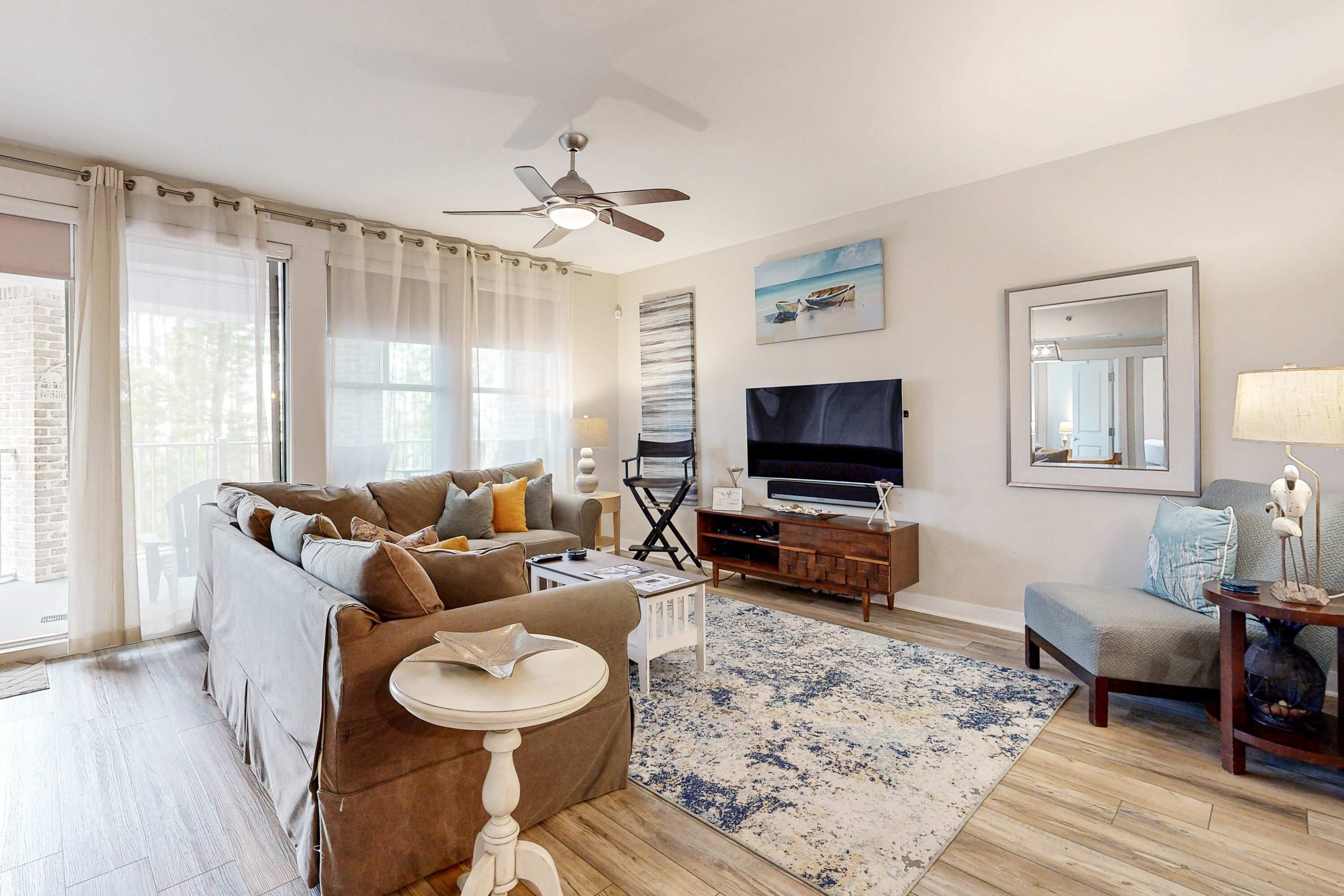 A living room with a sofa, TV, and a ceiling fan.