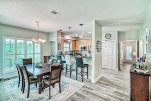 A spacious kitchen with wooden cabinets, a central island, and pendant lighting. - Gorgeous dog-friendly home with private pool & close to everything (Santa Rosa Beach)