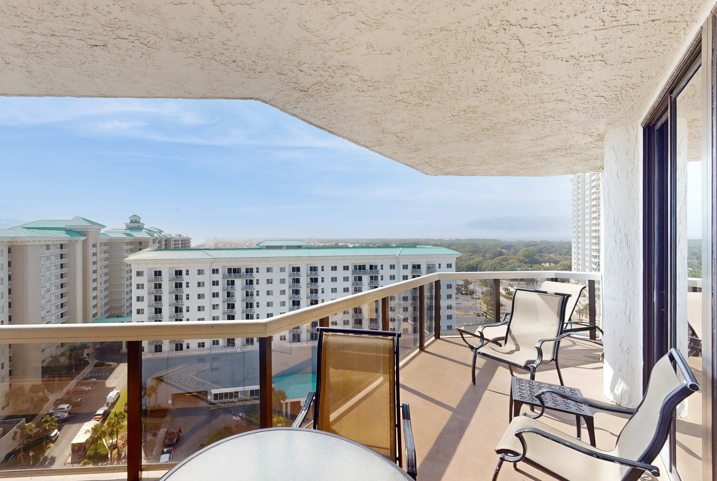 A balcony with a view of a hotel and surrounding buildings.
