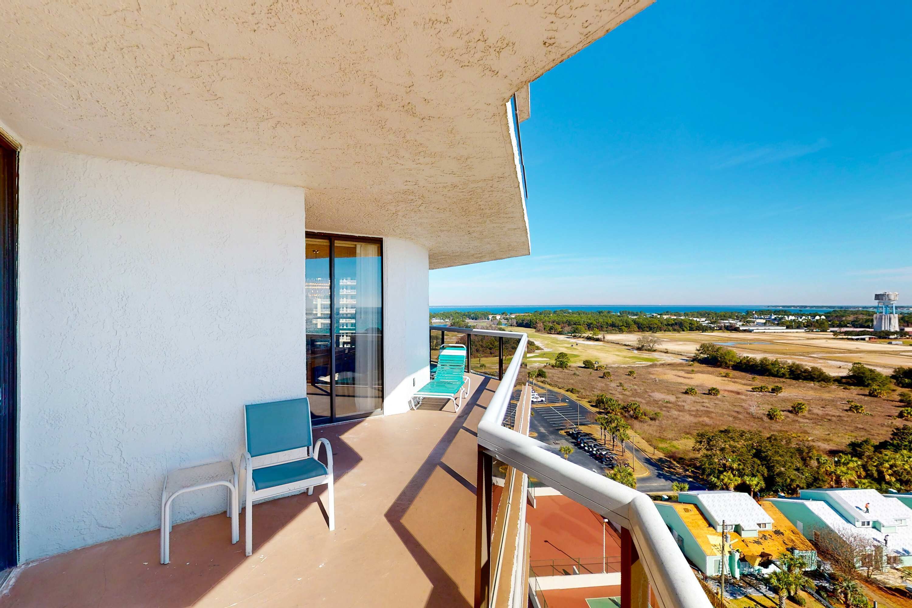 Un balcó amb vista a un camp de golf i edificis.