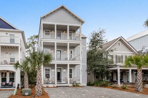A multi-story building with balconies, a covered front porch, and a paved driveway. - Classic beach home with shared pool access, WiFi, and central air conditioning (Santa Rosa Beach)