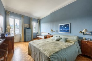 A bedroom with a bed, bedside tables, a desk, and a chair. - Starway to Heaven Apartment (Firenze)