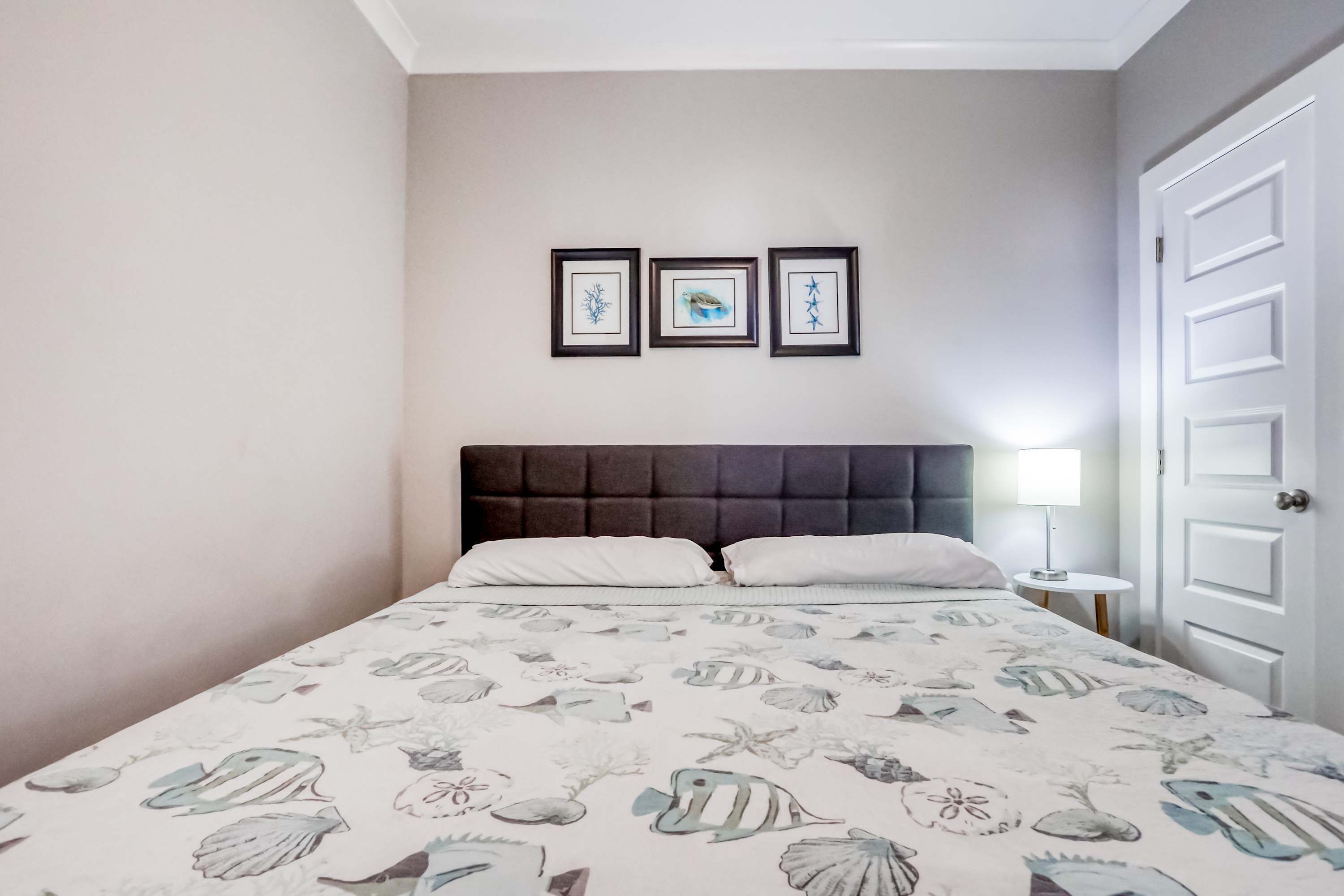 Une chambre à coucher avec un lit, une table de chevet et une porte.