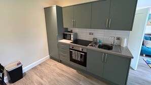 Eine moderne Küche mit grauen Schränken, einem Backofen und einer Mikrowelle.