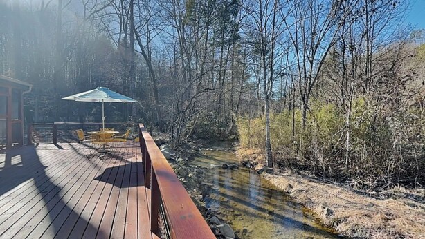 A wooden deck with outdoor seating and a view of a river. - Caney Creek | Great Views, Large Deck (Cosby)