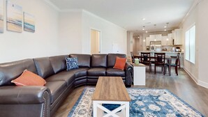 A modern living room with a sectional sofa, a coffee table, and a patterned rug. - Spacious townhome, dog-friendly w full kitchen & shared pool (Navarre)