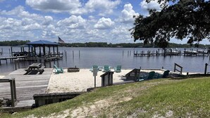 A lakeside dock with a covered pavilion, picnic tables, and lounge chairs. - Spacious townhome, dog-friendly w full kitchen & shared pool (Navarre)