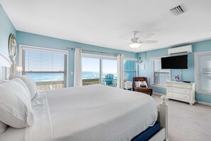 A bedroom with a large bed, a ceiling fan, a TV, and a view of the ocean. - Beachfront Townhome with Beautiful Gulf Views, Decks, WiFi, Laundry, & AC! (Navarre Beach)