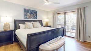 A bedroom with a large bed, a ceiling fan, a bench, and a balcony with curtains. - Bright Townhouse with High-Speed WiFi, Private Washer&Dryer, and Pool (Santa Rosa Beach)