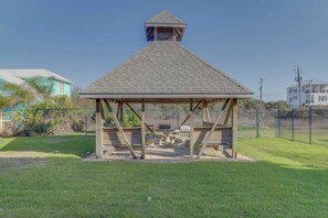 Ein Gazebo mit einem dreieckigen Dach und einer kleinen, turmartigen Konstruktion darauf.