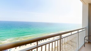 Ein Balkon mit Blick auf Strand und Meer.