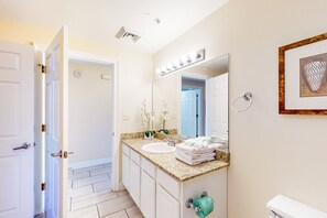 Een badkamer met een wastafel, spiegel en toilet.