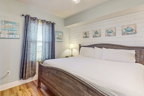 Un dormitorio con cama de madera, una mesita de noche, una lámpara y decoración en la pared.