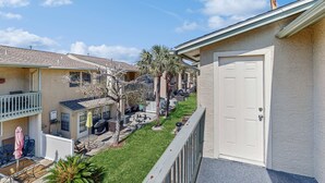 A residential area with houses, a grassy lawn, and a balcony with outdoor furniture. - Beachy townhouse with 11 pools, golf, fast WiFi & private WD (Panama City Beach)
