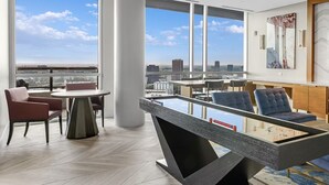 A modern living room with a pool table, comfortable seating, a flat-screen TV, and a city view. - FIFA Luxury-1BR Presidential Ste-Parking Incl.-Walk to Stadium-Sleeps 4 (Atlanta)