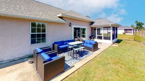 Una casa residencial con un patio amoblado y un porche techado.