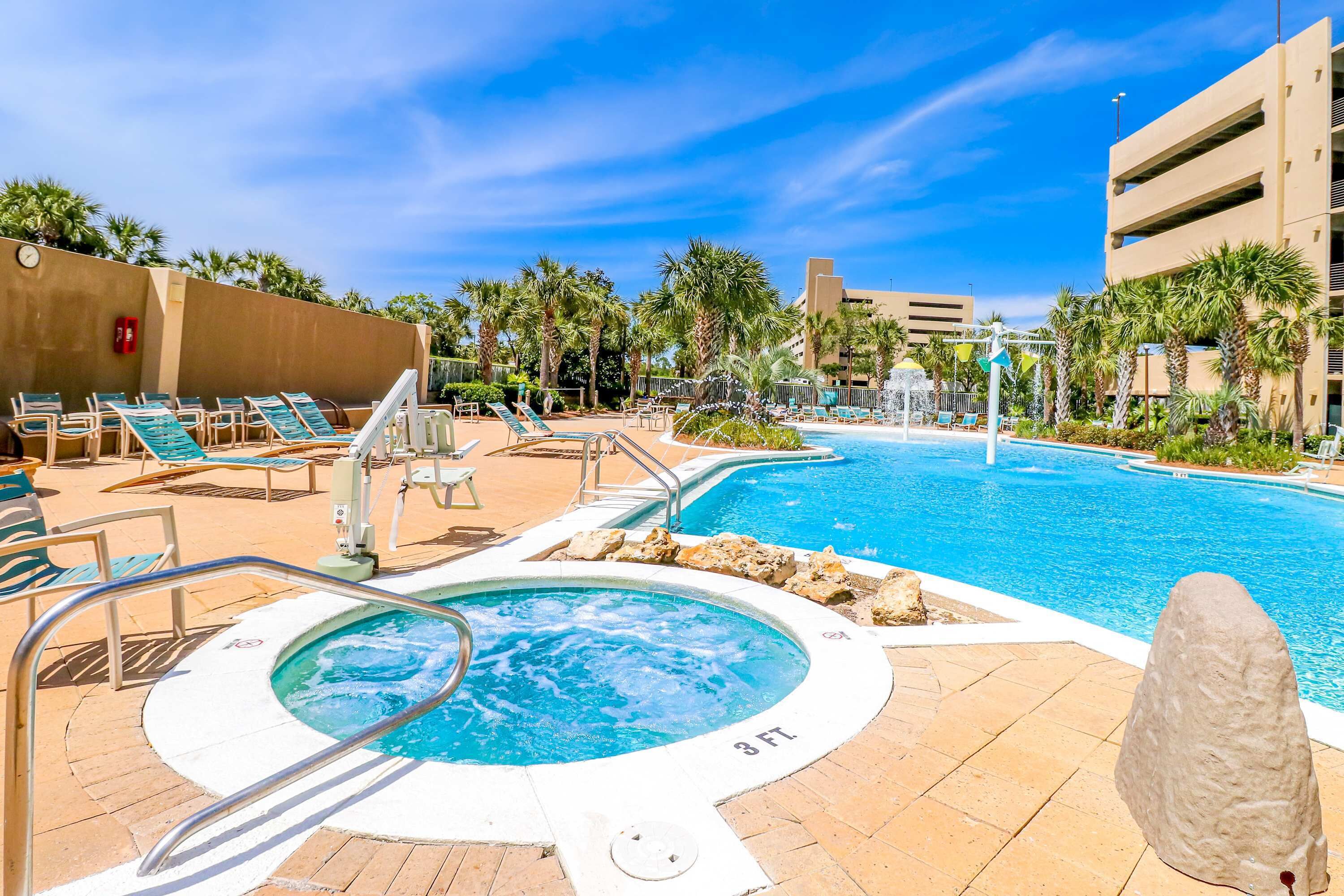 Un área de piscina con sillones de descanso, un jacuzzi y una fuente.