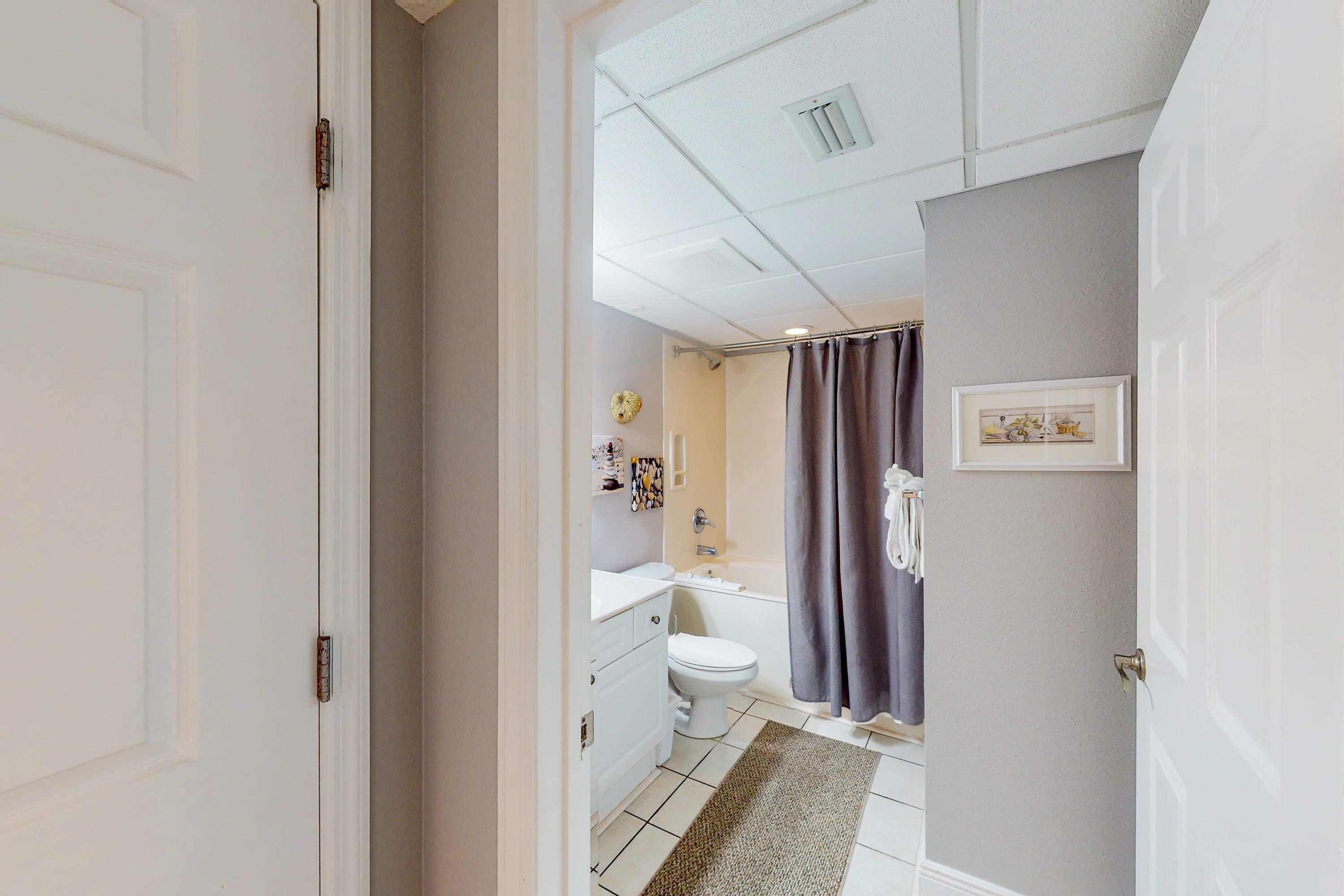 A bathroom with a toilet, sink, and shower curtain.