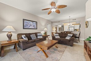 A living room with two sofas, a coffee table, and a ceiling fan. - 7th Floor Lovely Condo w/ Outdoor Pool Heated Seasonally, On The Beach (Navarre Beach)