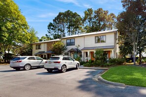 A two-story building with a parking lot, two white cars parked in front, and a well-maintained lawn. - Lakefront Duplex with High-Speed Wi-Fi, Short Walk to Beach, and Water View (Santa Rosa Beach)