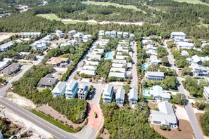 Vista aérea de una zona residencial con varias casas, carreteras y un campo de golf al fondo.