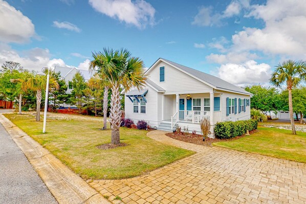 A single-story house with a front porch, a driveway, and a well-maintained lawn. - Charming home with enclosed sunroom, porch, central AC, & W&D - near beach (Santa Rosa Beach)