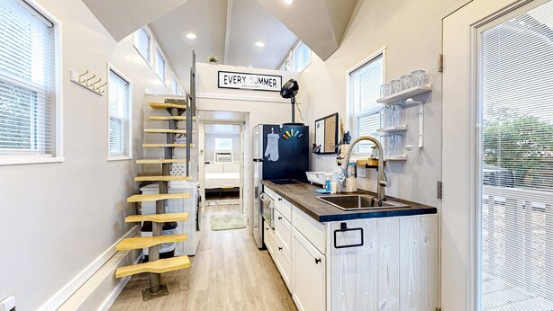 A modern kitchen with a central island, wooden ladder, and a sign that reads "EVERY SUMMER". - Peaceful & sun-soaked getaway with fire pit & W&D - near beaches, trails, & golf (Navarre)