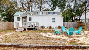 A small, single-story house with a front porch and a deck. - Peaceful & sun-soaked getaway with fire pit & W&D - near beaches, trails, & golf (Navarre)