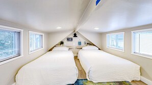A bedroom with two single beds, a ceiling fan, and a view of the beach through the windows. - Peaceful & sun-soaked getaway with fire pit & W&D - near beaches, trails, & golf (Navarre)