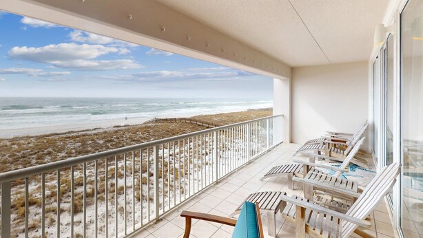 Een balkon met uitzicht op het strand en de oceaan.