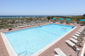 A rectangular swimming pool with clear blue water, surrounded by lounge chairs and umbrellas. - Updated 3rd floor condo w/ beach access and complementary BEACH SERVICE (Navarre Beach)