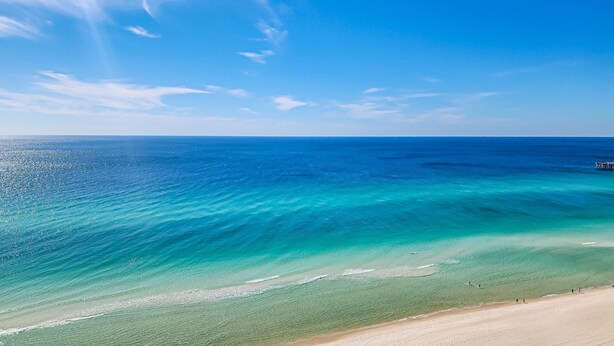 A beach with clear turquoise waters and a sandy shore. - 16th-floor condo with Gulf views, beach access, 2 pools, hot tub, & private W&D (Panama City Beach)