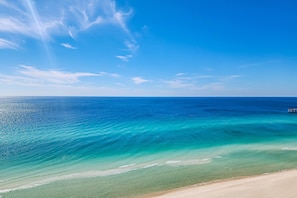Ein Strand mit klarem türkisblauem Wasser und einem Sandufer.