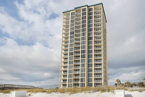 A tall, multi-story hotel with a symmetrical facade, numerous balconies, and a flat roof. - 11th Floor Gulf Front Condo Great Amenities & Private Beach Access (Navarre Beach)