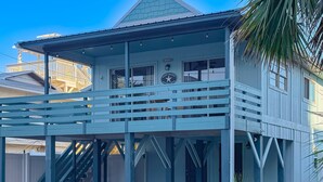 A two-story house with a balcony, a staircase, and a porch. - Gorgeous home with private pool, outdoor space and close to beach (Panama City Beach)