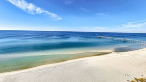 Uma praia com um píer que se estende sobre a água.