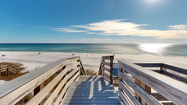 A wooden boardwalk leading to a beach with a clear sky and the sun shining. - Courtyard view condo with private beach access, private balcony, & free WiFi (Santa Rosa Beach)