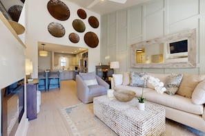A spacious living room with a sofa, coffee table, and decorative wall art. - Courtyard view condo with private beach access, private balcony, & free WiFi (Santa Rosa Beach)