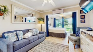 Een slaapkamer met een groot bed, een sofa, een bureau en een televisie.