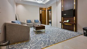 Un salon moderne avec un canapé, une table basse et un téléviseur à écran plat fixé au mur.