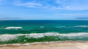 Una platja amb aigua blava cristal·lina i sorra daurada.