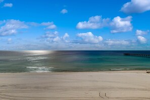 A beach with a clear sky and a pier extending into the water. - Beachfront condo with pool, gym, beach access, Gulf views, balcony, AC (Panama City Beach)