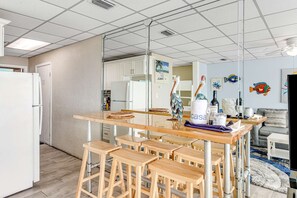 A modern kitchen with a central island, bar stools, and a refrigerator. - Beachfront condo with central AC, WiFi, access to pool, washer&dryer (Panama City Beach)