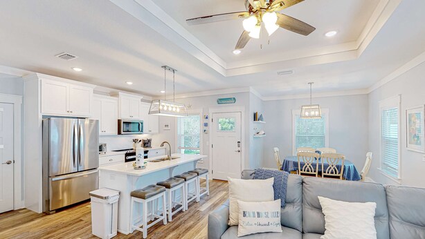 A modern kitchen with white cabinets, stainless steel appliances, and a bar area. - Newly built dog-friendly home with spacious backyard & private W&D (Panama City Beach)
