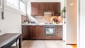 Una cocina moderna con armarios de madera oscura, una campana extractora de acero inoxidable y un horno empotrado.