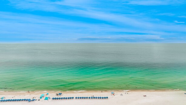 Ein Strand mit klarem türkisblauem Wasser und einem sandigen Ufer.